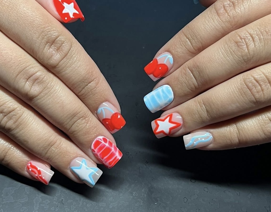 Red, white, and blue nail art with cherries and stars