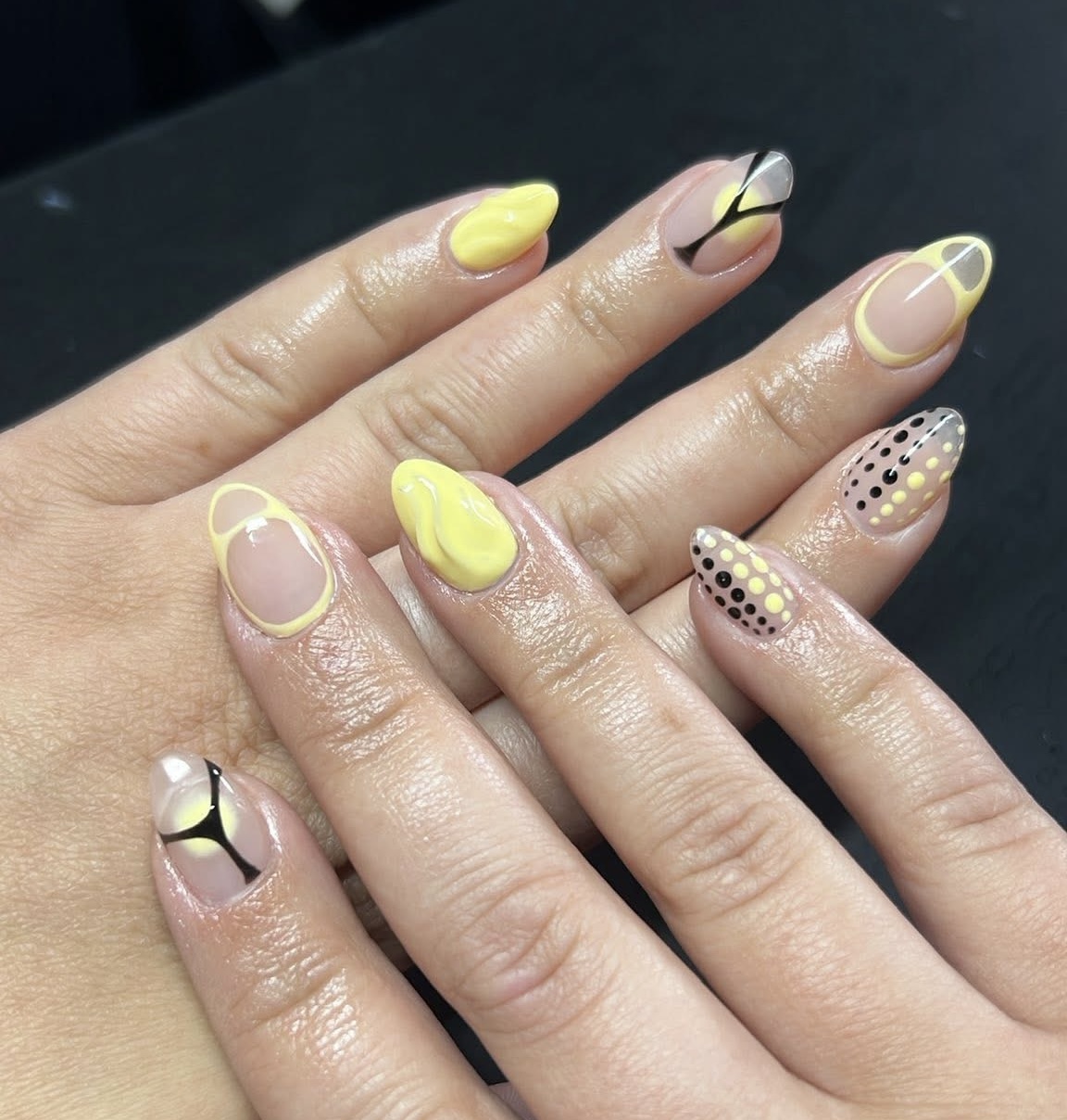 Yellow and nude nails with black abstract geometric designs